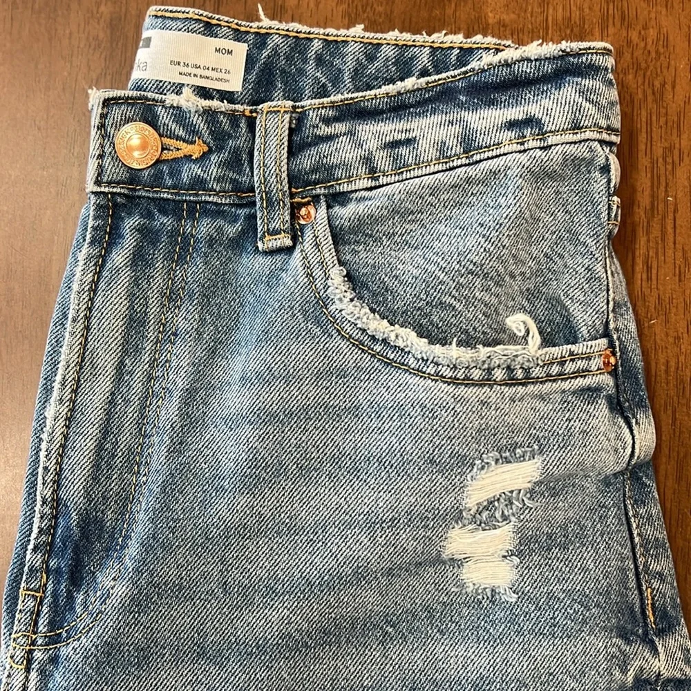 Bershka mom jeans high rise.  with rip in blue. Busted knee Size 4